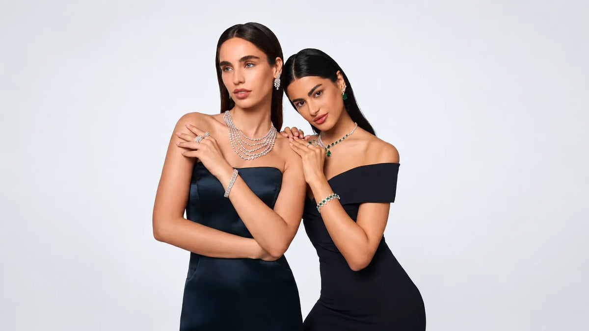 Spectrum Jewels models wearing diamond and gemstone jewelry in elegant black gowns with layered gold-tone pieces.