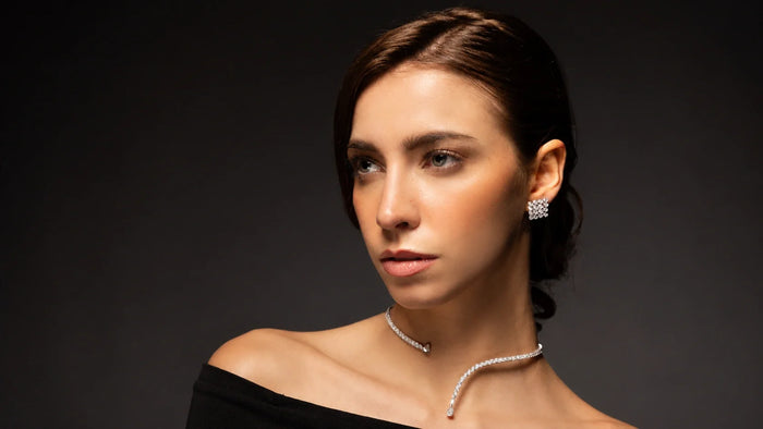 Spectrum Jewels model wearing diamond stud earrings and a delicate diamond choker necklace in an elegant black outfit.