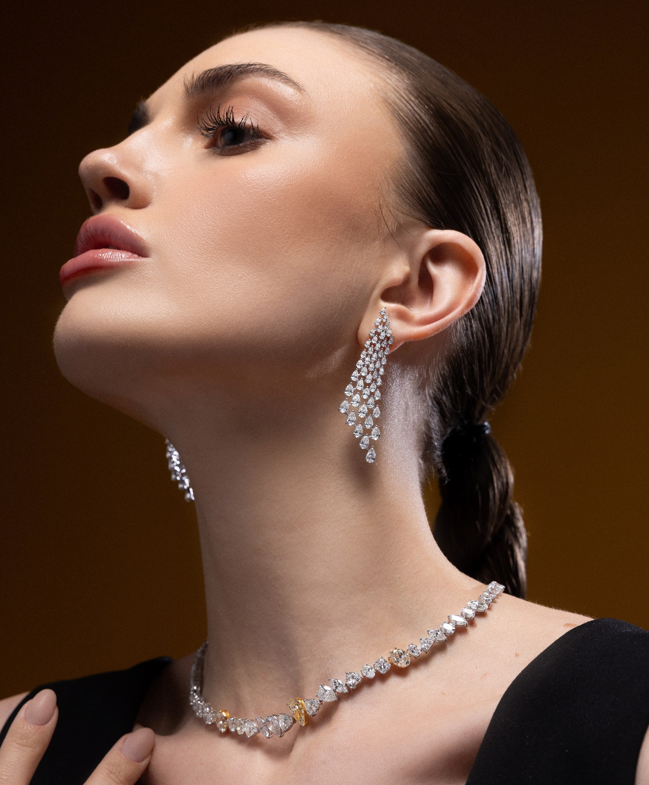 Model wearing Spectrum Jewels cascading natural diamond chandelier earrings with a statement diamond necklace.