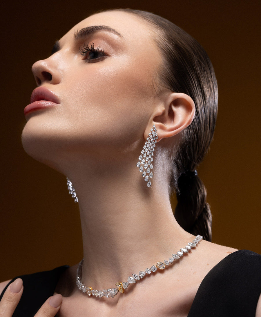 Model wearing Spectrum Jewels cascading natural diamond chandelier earrings with a statement diamond necklace.